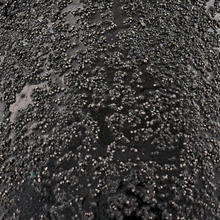 Load image into Gallery viewer, Close-up of a textured black surface with intricate patterns