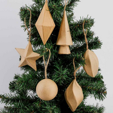 Load image into Gallery viewer, A set of six natural wood geometric Christmas tree ornaments hanging on a green artificial Christmas tree against a light gray background.