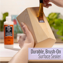 Load image into Gallery viewer, Person applying a brush-on surface sealer to a wooden block with a bottle of sealer in the background.