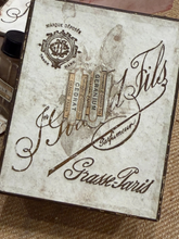 Load image into Gallery viewer, A vintage-style decorative box lid or plaque with distressed cream/off-white coloring and dark brown printed script and illustration. Visible text includes 'Marque Déposée', 'Cédrat', 'Géranium', and 'Grasse-Paris'.