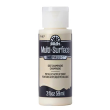Load image into Gallery viewer, A bottle of FolkArt Multi-Surface Metallic acrylic paint in the shade 6307 Champagne, featuring a cream-colored body and a white cap on a plain white background.