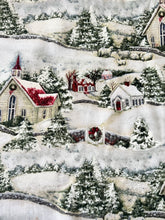 Load image into Gallery viewer, A close-up of a Susan Winget Christmas-themed fabric print featuring snow-covered hills, evergreen trees, small houses, and a church with red roofs and wreaths.