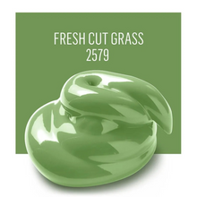 Load image into Gallery viewer, Green cream with a leaf-shaped container on a green background labeled 'Fresh Cut Grass 2579'.