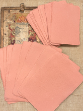 Load image into Gallery viewer, A fan of handmade coral pink paper cards or napkins displayed on a textured beige burlap background next to a vintage floral card.