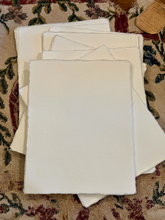 Load image into Gallery viewer, Stack of white fabric pieces on a patterned fabric background