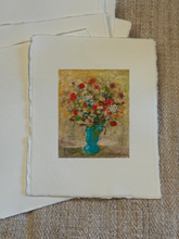 Load image into Gallery viewer, A square art print with a wide white border featuring a colorful still life painting of a flower bouquet in a blue vase, displayed on a textured beige fabric background.