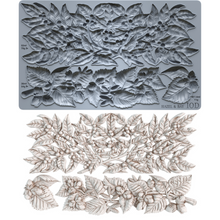 Load image into Gallery viewer, A gray silicone baking or craft mold sheet with embossed floral and leaf patterns, shown above a set of matching light beige carved floral and leaf pieces on a white background.