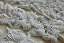 Load image into Gallery viewer, White carved floral and leaf relief sculpture on a light beige background.