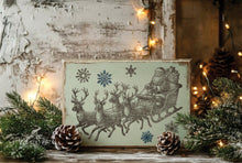 Load image into Gallery viewer, A rectangular vintage-style Christmas sign featuring Santa Claus in a sleigh with reindeer and snowflakes, styled on a rustic wooden surface with pine branches, pinecones, and warm string lights.