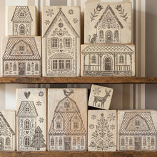 Load image into Gallery viewer, A set of wooden house-shaped rubber stamps with intricate black printed designs, displayed on rustic wooden shelves against a striped wall.