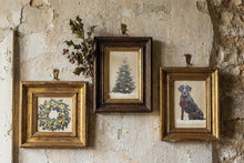 Load image into Gallery viewer, Three framed vintage-style art prints hanging on a textured, rustic plaster wall. The left frame is gold and depicts a floral wreath.