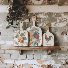 Load image into Gallery viewer, IOD Saint Ouen Transfer designs depicted on decorative cutting boards with the floral and rooster designs on a rustic shelf against a brick wall.
