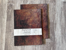 Load image into Gallery viewer, A close up view of two Roycycled Treausures Art Journals rustic dark brown distressed covers on wood background