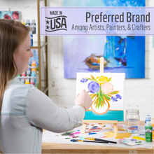 Load image into Gallery viewer, Person painting a floral scene on an easel with a 'Made in USA' brand banner above.