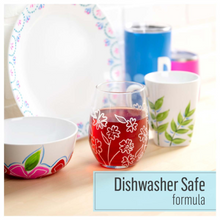 Load image into Gallery viewer, Colorful ceramic dishes including a glass with floral design on a wooden surface.