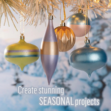 Load image into Gallery viewer, Decorative Christmas ornaments hanging on a tree with a blurred snowy background.