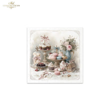 Load image into Gallery viewer, A square decorative print or card featuring a pastel still life of cupcakes, macarons, flowers, and small decorative objects on a table, centered on a white background. The top-left corner of the image shows the text 'Ade Collection' as a watermark or brand mark.