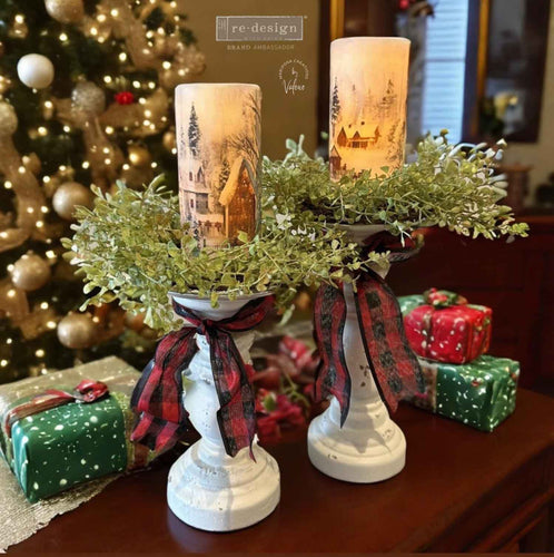 Decorative candle holders with Christmas-themed candles in a festive setting.