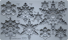 Load image into Gallery viewer, A gray silicone mold tray featuring multiple ornate snowflake designs of varying sizes, each labeled with its volume in milliliters and weight in grams. The bottom left corner displays the text 'SNOWFLAKES IOD'.