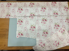 Load image into Gallery viewer, Floral-patterned Urban Gardens Pink Rose Bouquets fabric wide view with tape measure for scale.